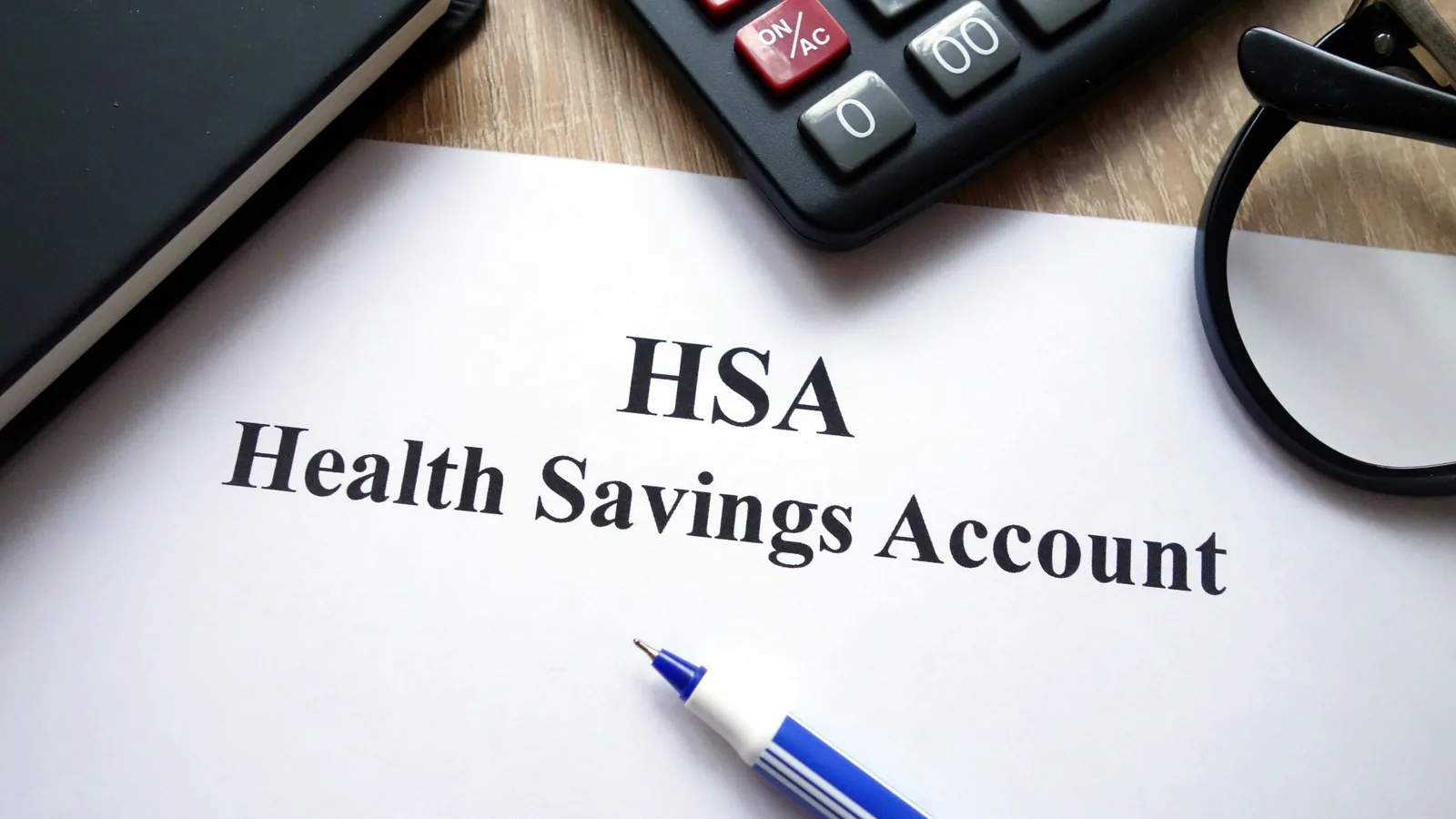 A printed Health Savings Account form on a desk with a calculator and a pen resting on it.